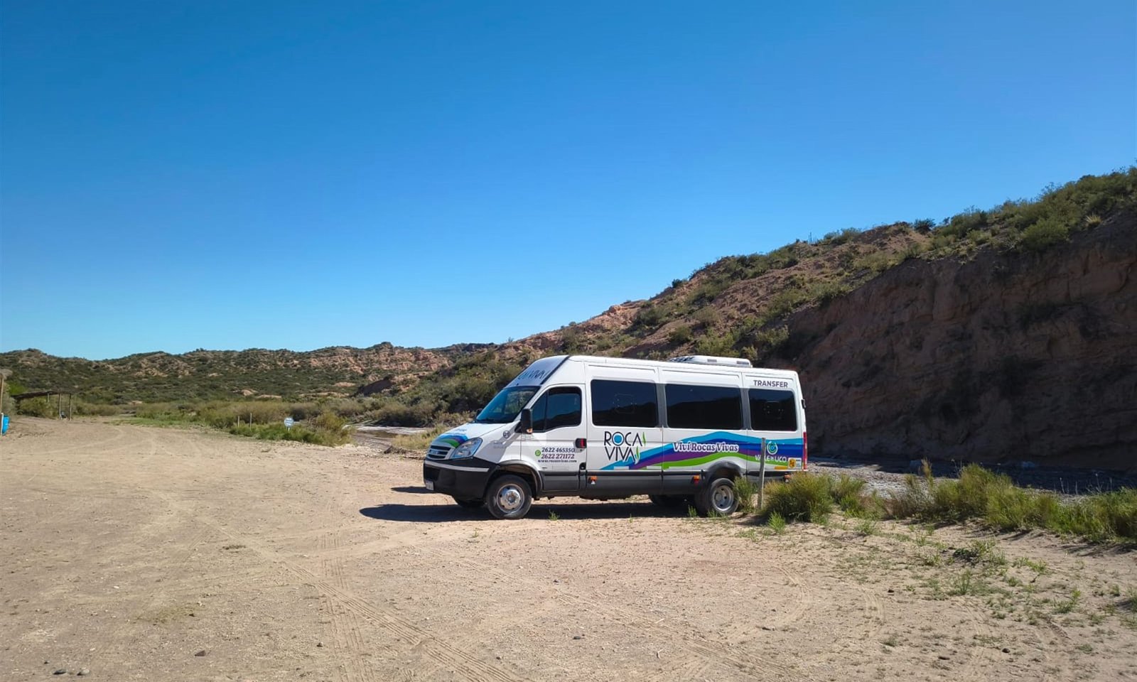 Minibús de Rocas Vivas Transfer sobre la Ruta 40, entre cerros del Valle de Uco